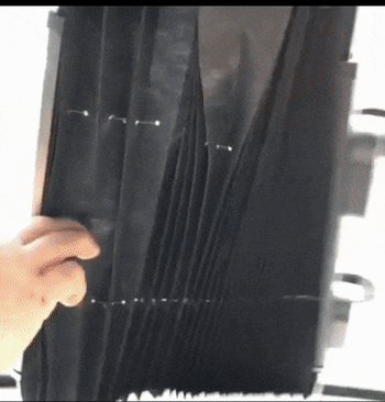 A reviewer demonstrating how the black visor extends over a car window for shade.