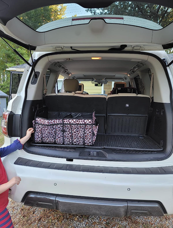 A rectangular leopard-print organizer occupying about a quarter of the trunk space, neatly storing various items.