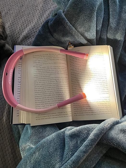 A reviewer’s photo showing their pink neck light illuminating a book