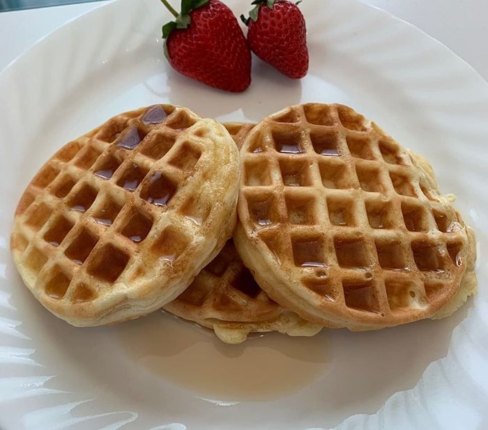 A photo from a reviewer showing waffles on a plate, topped with fresh strawberries.