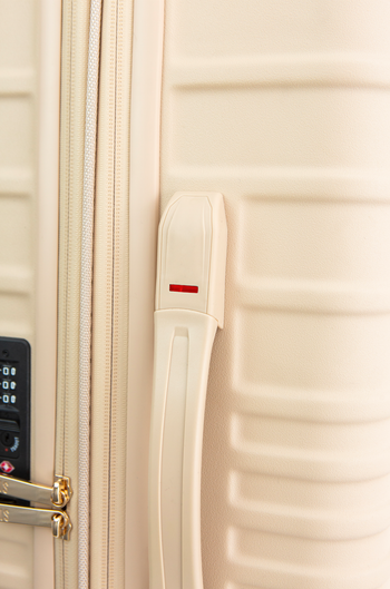 A close-up of the suitcase in black, highlighting the red weight indicator on the side handle.