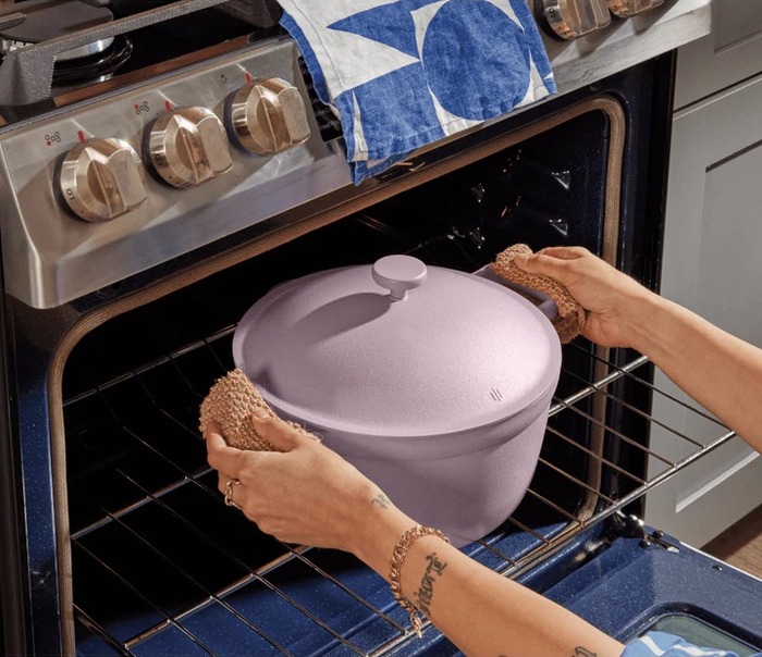 Arms placing the lavender pot into an oven.
