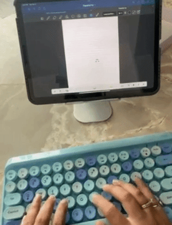 A reviewer typing away on a blue version of the keyboard