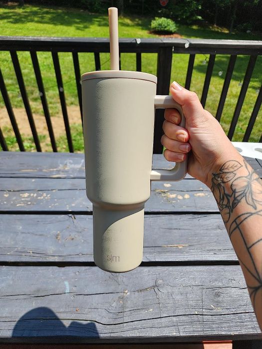 reviewer showcasing the beige tumbler
