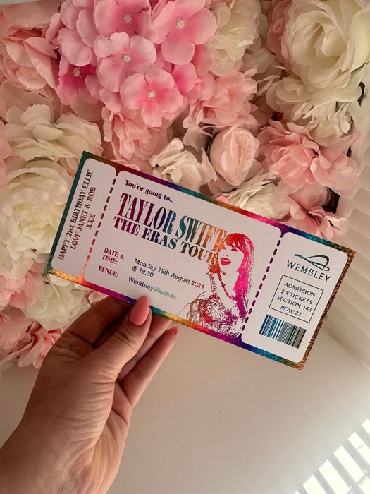 A hand grips a Taylor Swift concert ticket for