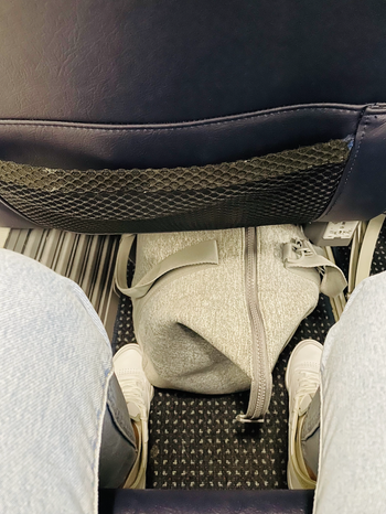 The grey duffle bag fits snugly under the seat in front of you on a plane.