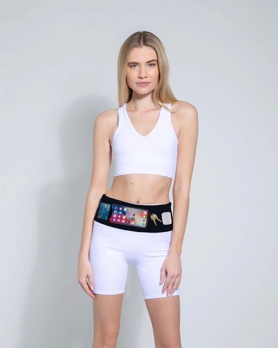 A model demonstrates wearing the black PocketCor belt, showing how it fits various items inside.