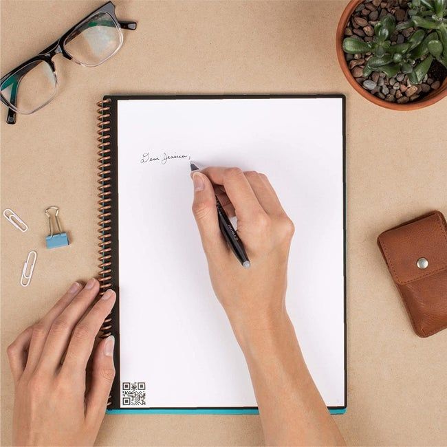 A model writing in a blank page of the reusable spiral-bound notebook.