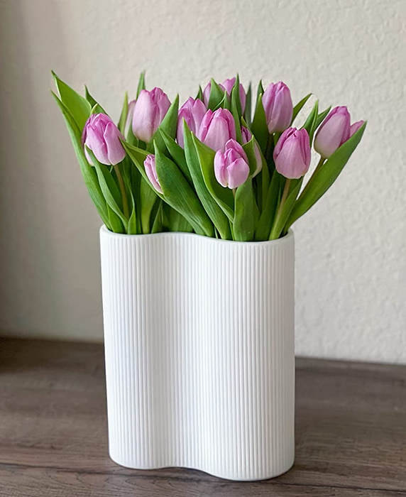 A reviewer photo showing the white vase filled with purple tulips.