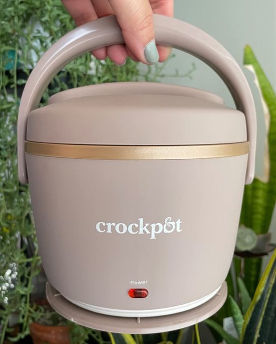 A reviewer holding up a blush pink portable Crock-Pot.