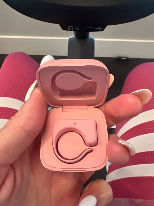 A reviewer holding up the pink remote inside its case.