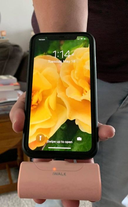 Reviewer showing the charger attached to their phone, successfully charging it.