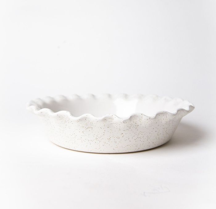 A side view of the speckled white ceramic pie dish, highlighting its unique design.