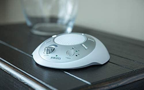 A white noise machine resting on the nightstand