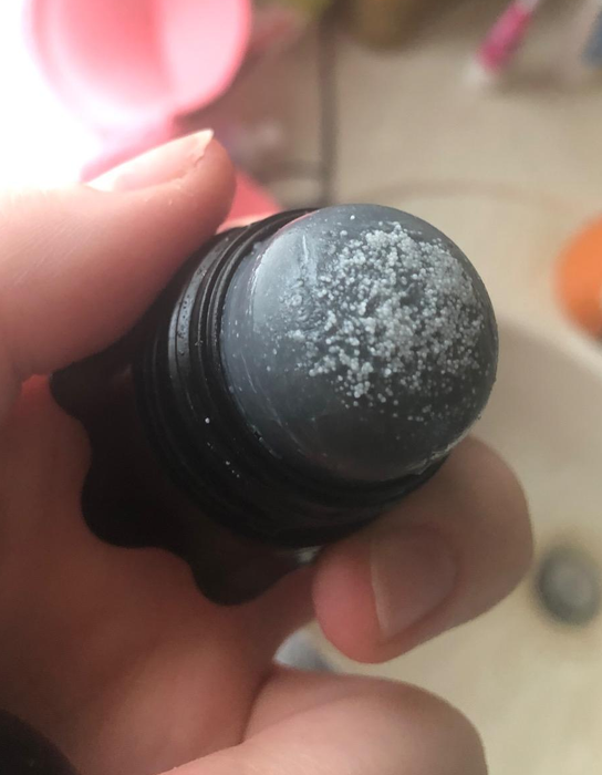 Another reviewer holding a scrub stick with visible blackheads and whiteheads on it