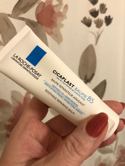 An image of a reviewer holding up a tube of healing cream.