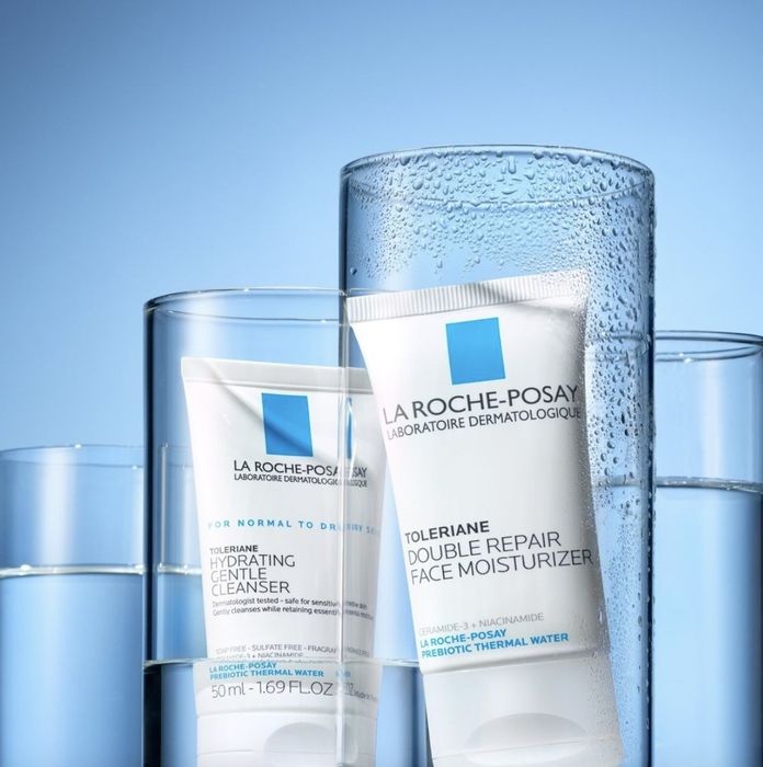 A tube of face moisturizer placed in a glass