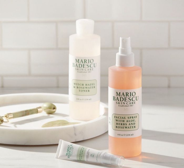 A bottle of facial mist, toner, eye serum, and a jade roller.