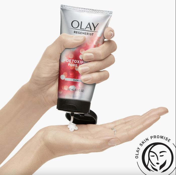 A person applying facial scrub to their skin