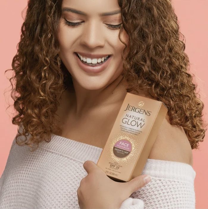 A person holding a self-tanner package.