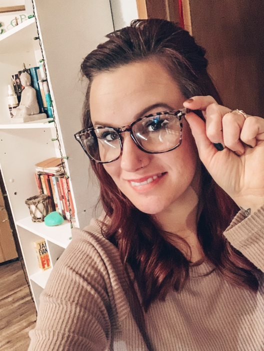 A reviewer wearing tortoiseshell patterned blue light glasses.