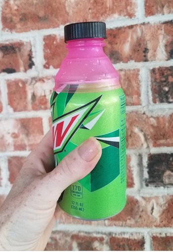 A Mountain Dew can with a silicone bottle lid attached on top.