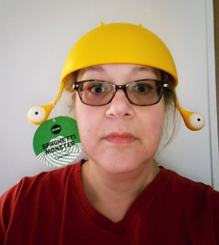 A reviewer sporting the colander upside down on her head, taking kitchen fashion to the next level.