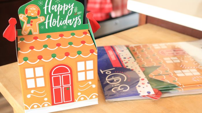 A festive paper gingerbread box placed on a table.