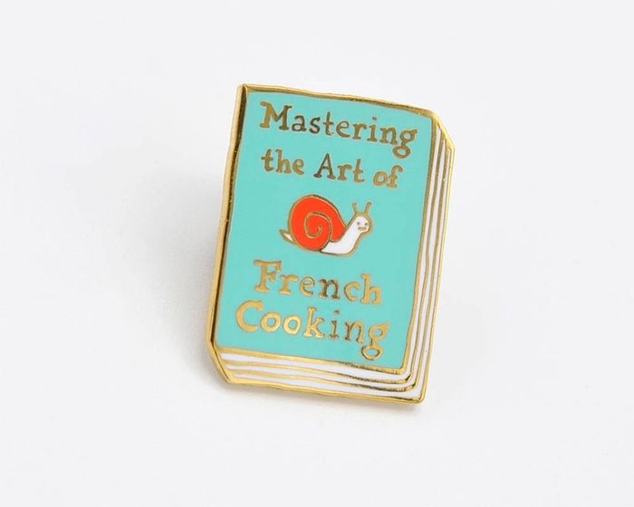 A delicate light blue book pin, embossed with the words
