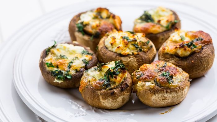 A plate of stuffed mushrooms on a crisp white dish.