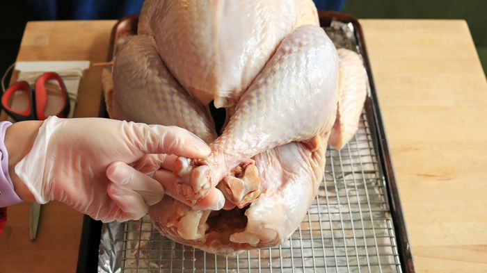 A hand gripping the crossed turkey legs.