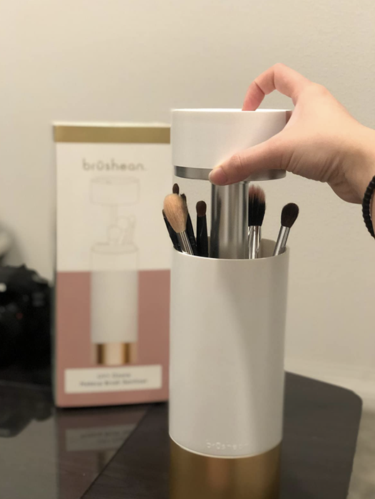 A different reviewer demonstrating how effortlessly the top of the sanitizer lifts to insert makeup brushes into it.