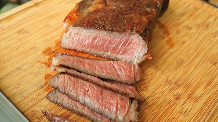 Sliced steak placed on a cutting board.