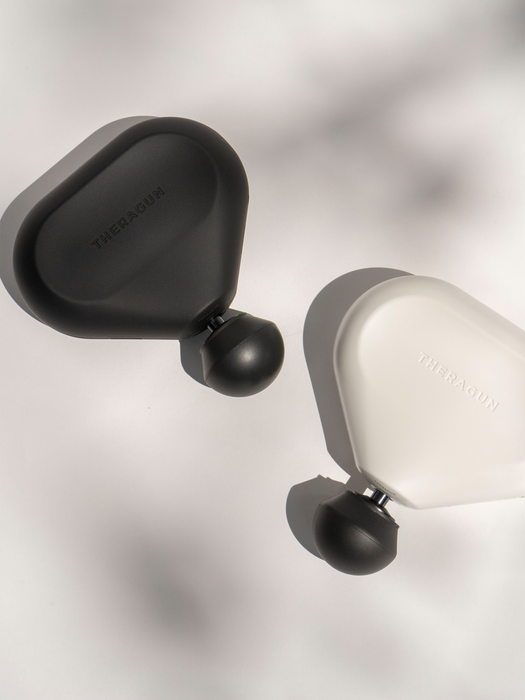 two mini Theraguns in black and white