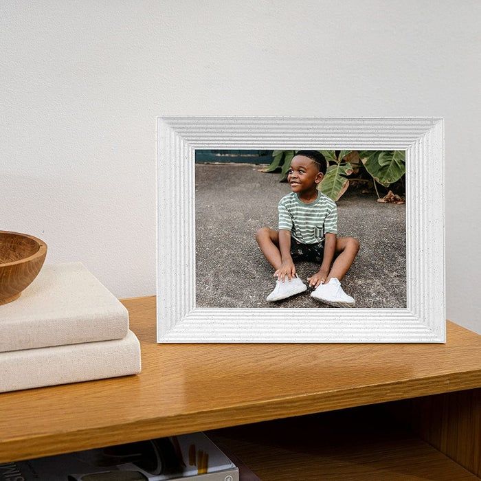 a picture of a child displayed in a white digital photo frame