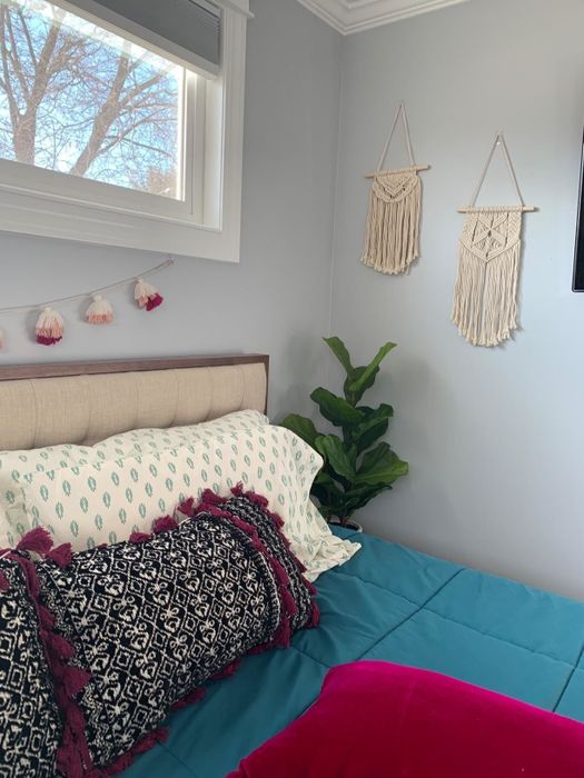 A photo from a reviewer showing the hangings on a wall next to a bed.