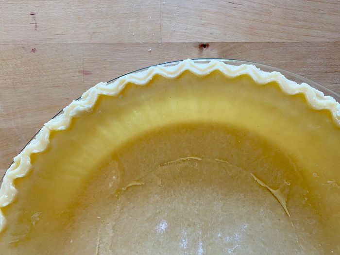 A pie crust in a clear glass pie dish.