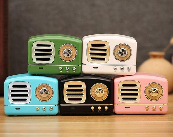 A collection of retro-inspired mini speakers arranged on a wooden surface, showcasing different designs with circular dials and buttons.