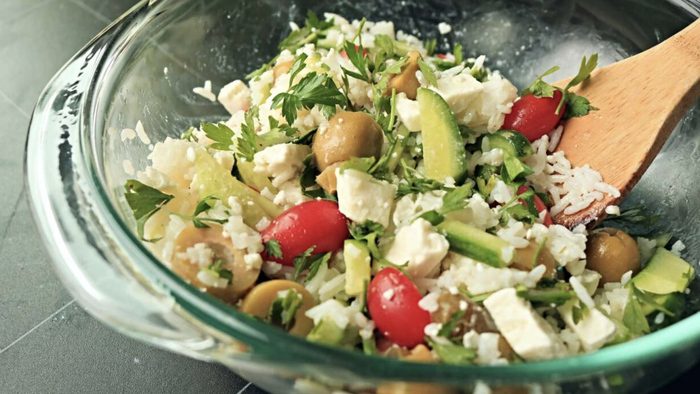 A vibrant rice and vegetable salad served on a table.