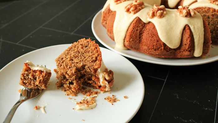 A half-eaten slice of walnut bundt cake resting on a plate.