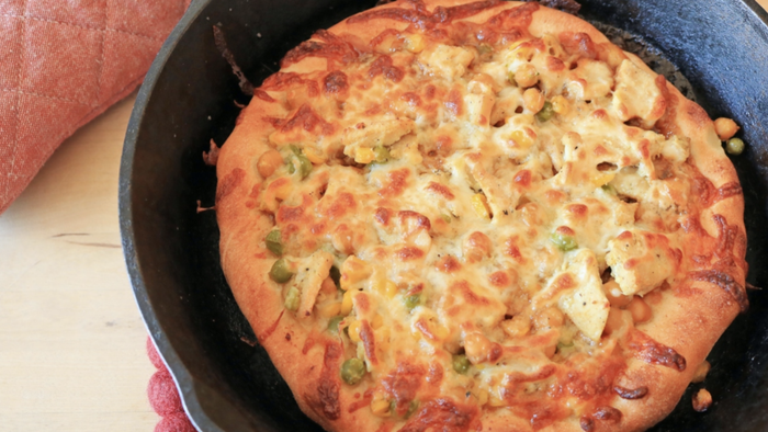 A pizza baked in a cast iron skillet.