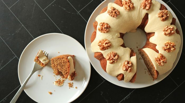A picture of a bundt cake topped with walnuts.