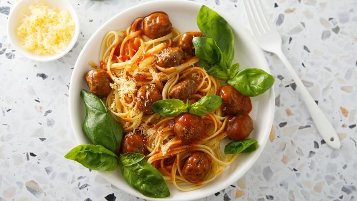 A plate of spaghetti and meatballs on a white dish