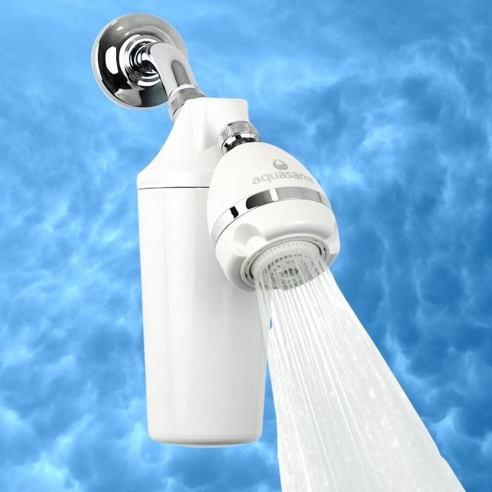 A shower filter labeled 'Aquasana' releasing water, captured against a cloudy sky background. Featured in an article discussing home water filtration products.