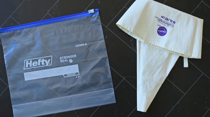 A plastic zip-top bag placed next to a piping bag.