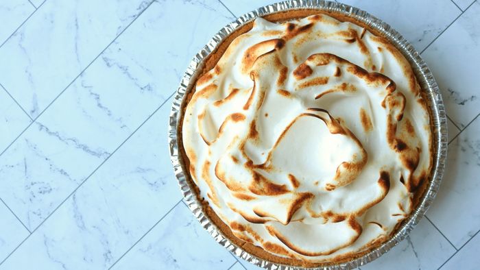 A lemon meringue pie resting on a countertop, ready to be devoured.