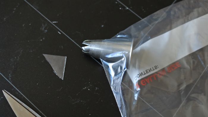 A piping tip coming through the corner of a plastic bag.