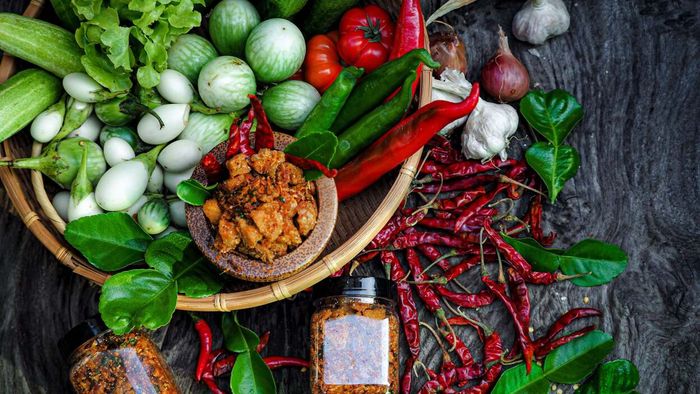 A selection of red chili peppers and other fresh produce arranged on a table.