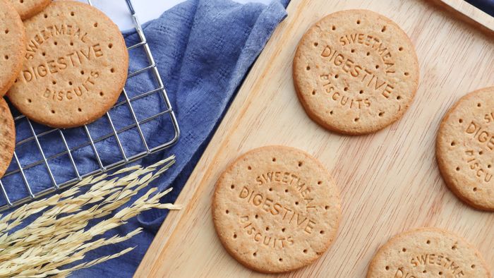 Digestive biscuits arranged on a wooden cutting board.