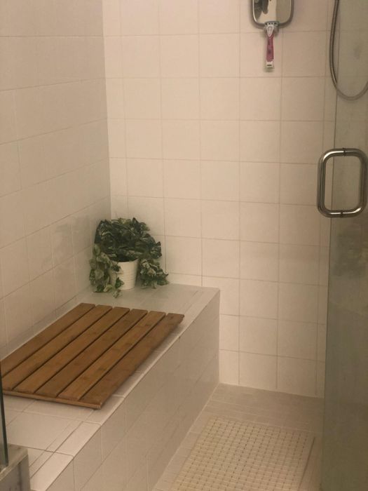 Another reviewer's image displaying the bath mat placed on a built-in shower bench.